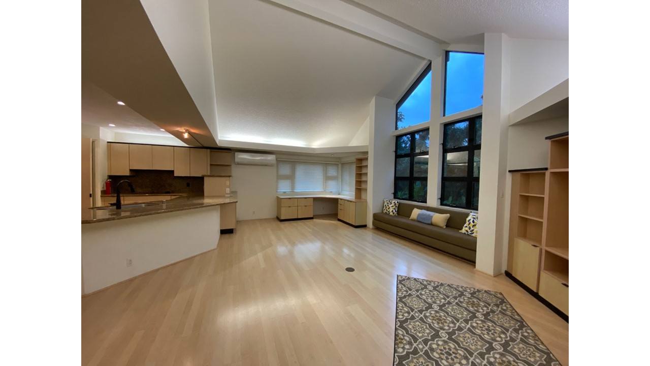A spacious living room with a fireplace and large windows.